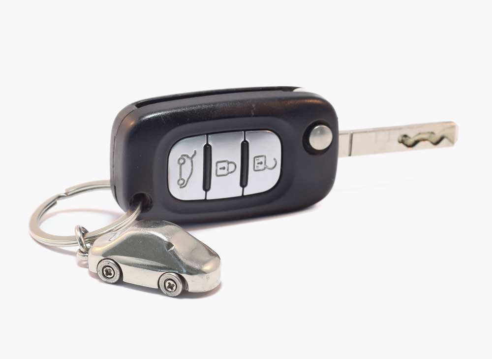 Close up of a car key with a car-shaped key chain